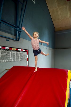 Mädchen steht auf Weichbodenmatte